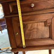 Antique wooden bedside table with turned legs.