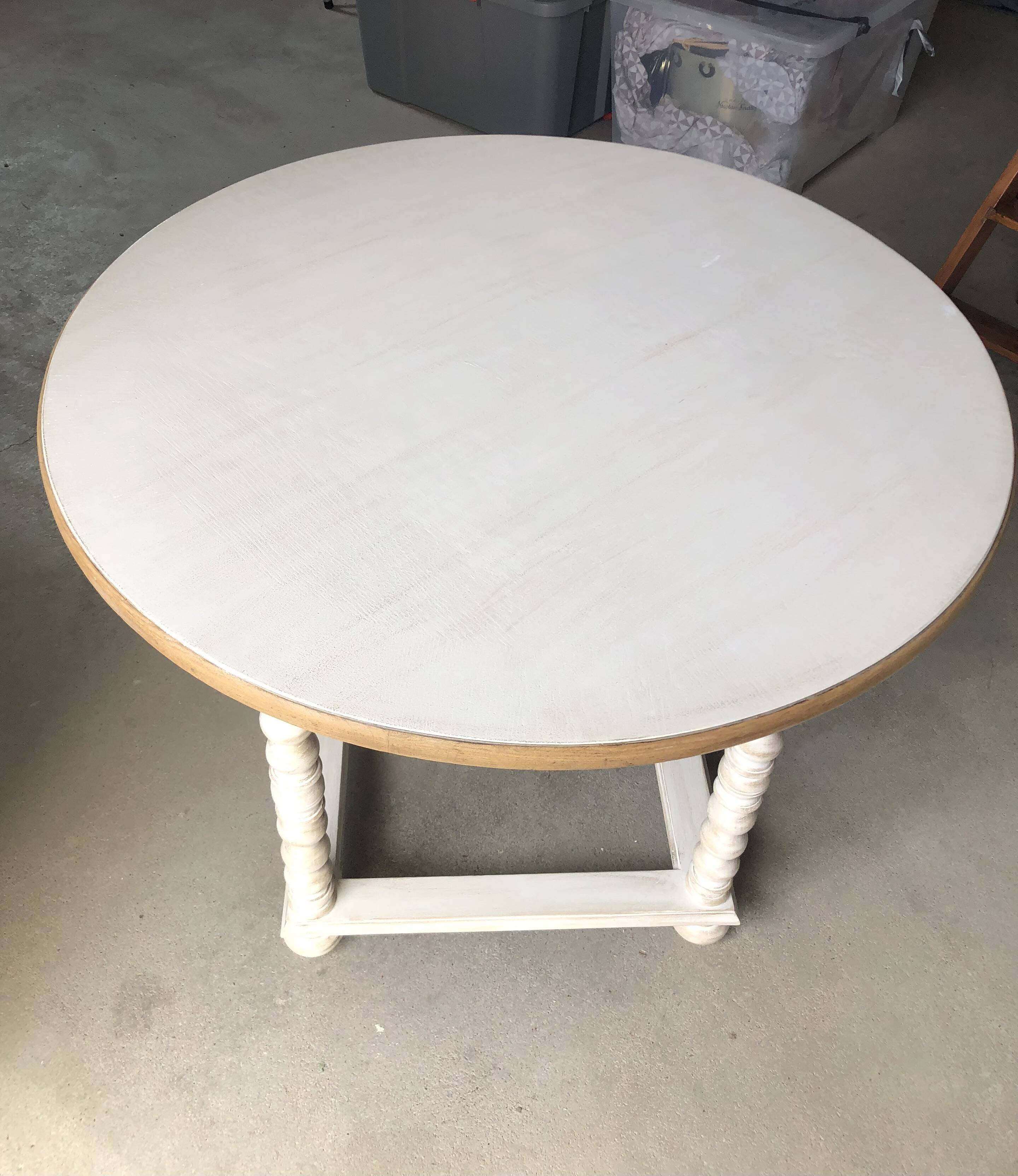 Antique round table refurbished in cerused white, with twisted legs.