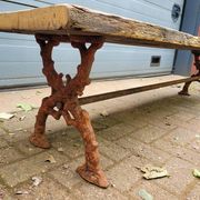 French country-style cast iron garden bench with old barn wood plank.