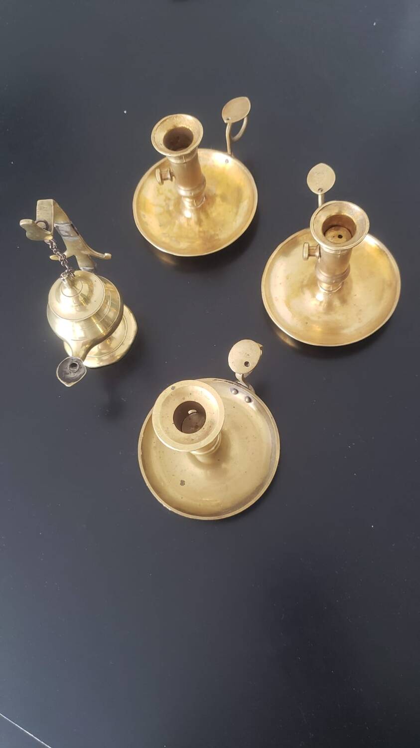 Many candlesticks and a small oil lamp.