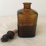 Old amber glass bottle with its wooden and cork stopper