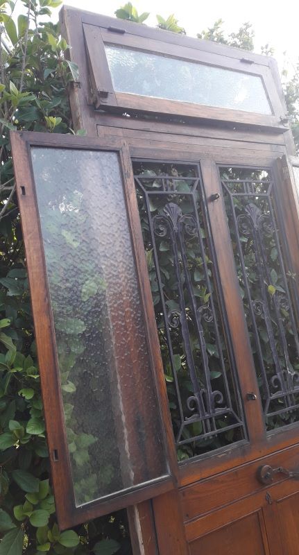 Oak entrance door and its frame and transom, wrought iron gates