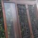 Oak entrance door and its frame and transom, wrought iron gates