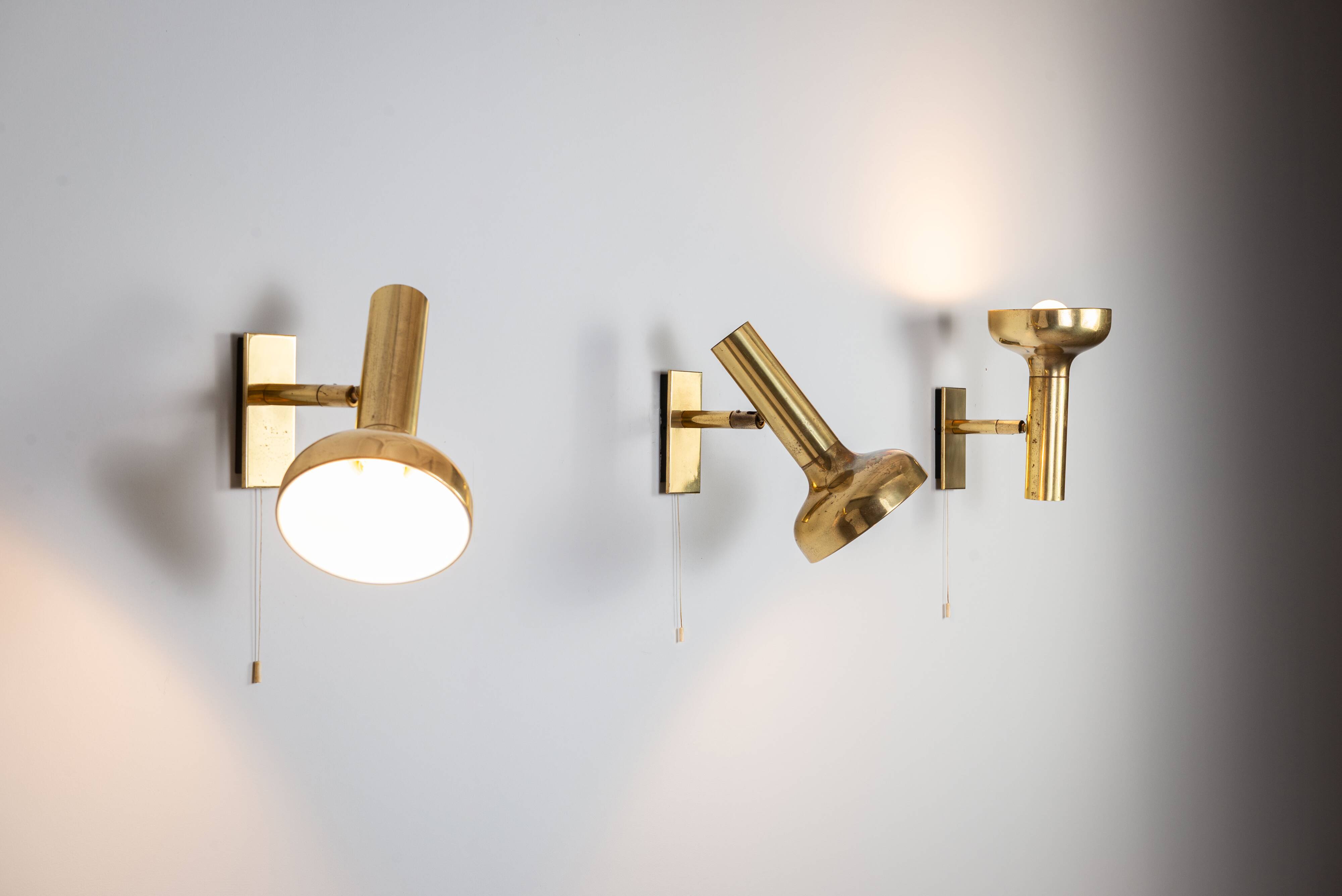 Set of three brass adjustable wall lamps