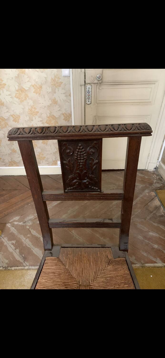 Antique carved wooden chairs with straw seats.