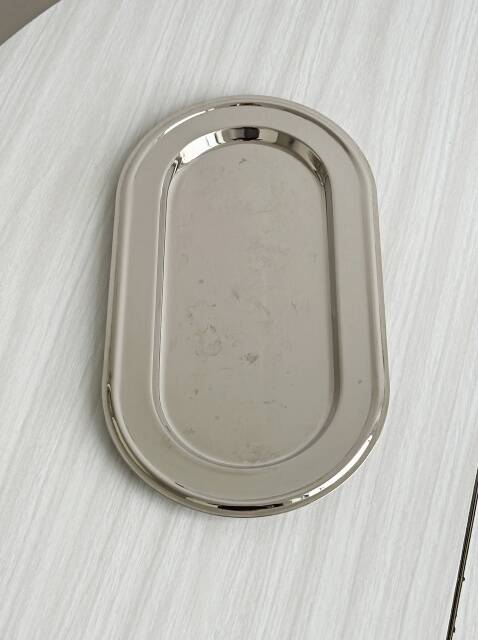 Small antique tray made of lightweight metal.