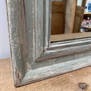 Antique mirror with a green and white patina.