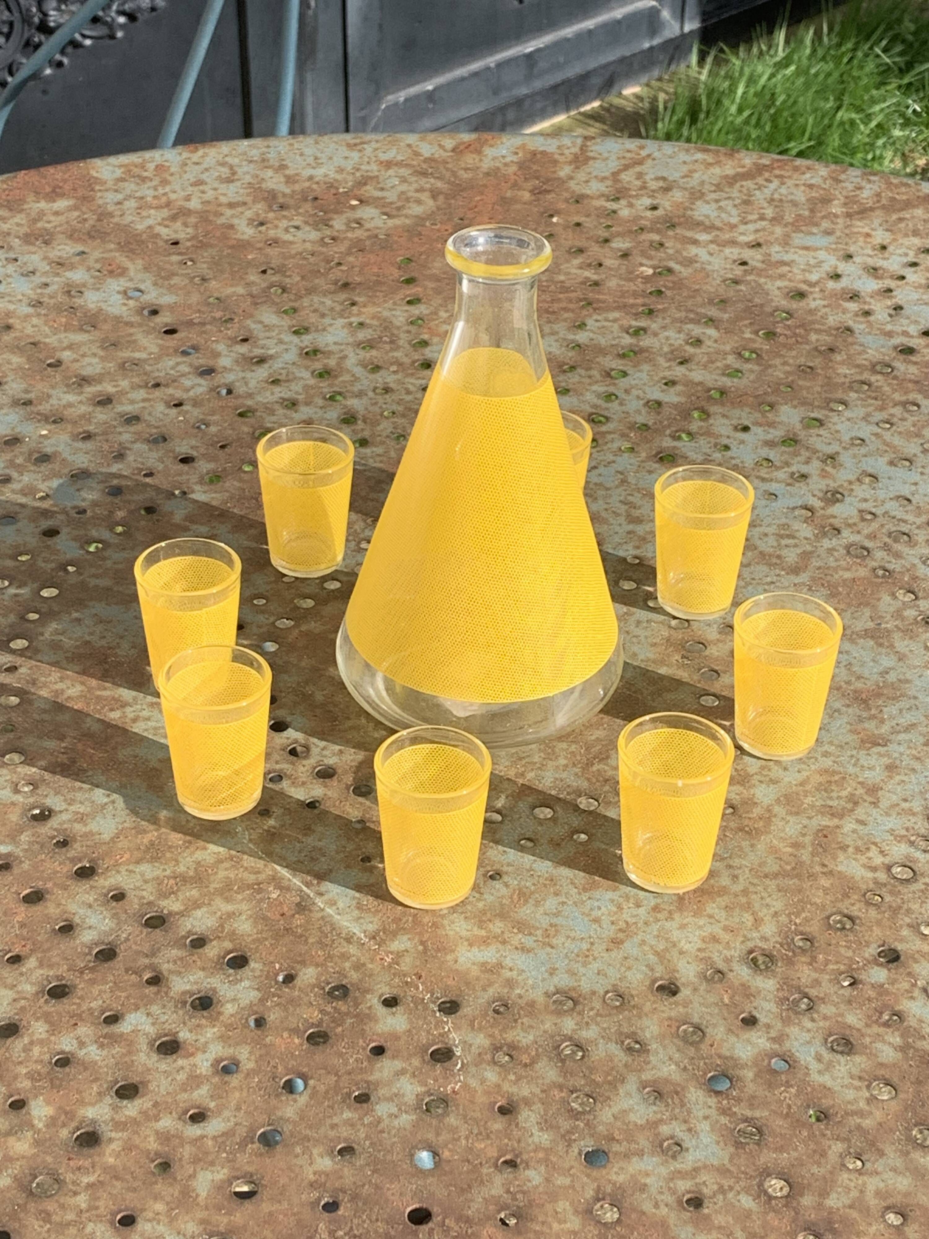 Liqueur service composed of a glass carafe and 8 small yellow screen-printed glasses