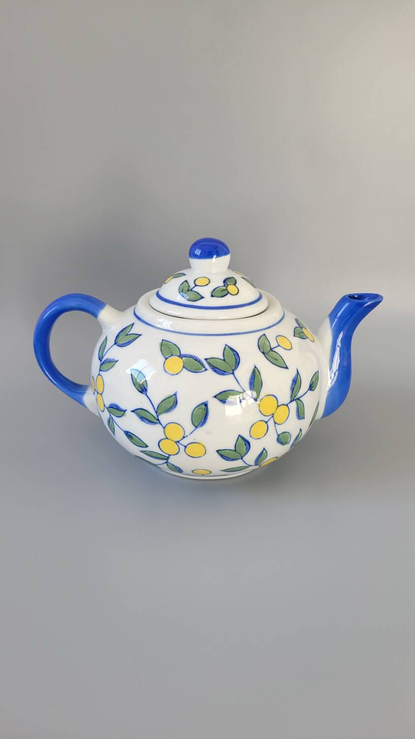 Blue teapot and yellow fruits