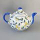 Blue teapot and yellow fruits
