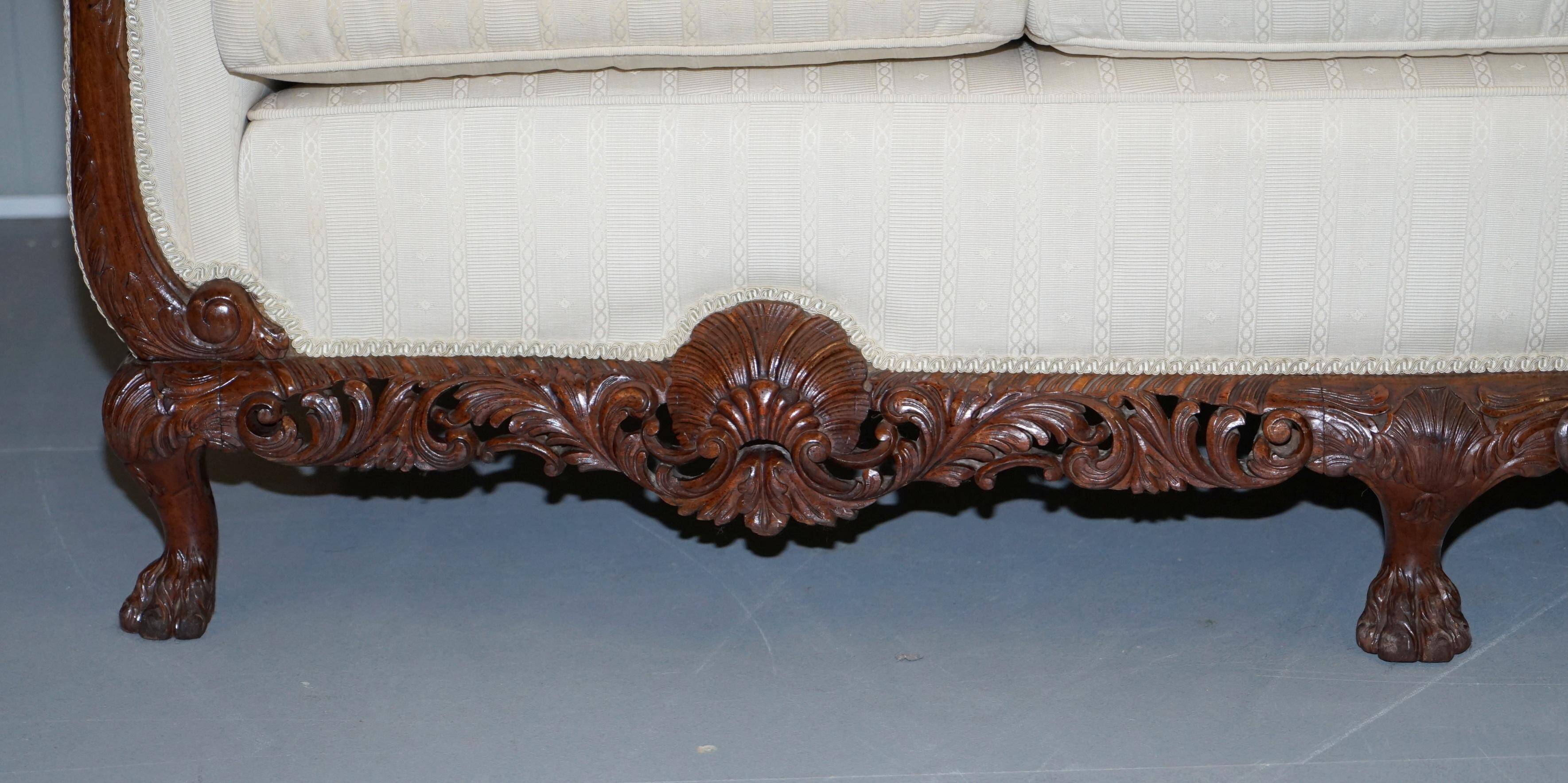 Three-seater canapé carved from solid walnut with claw feet.