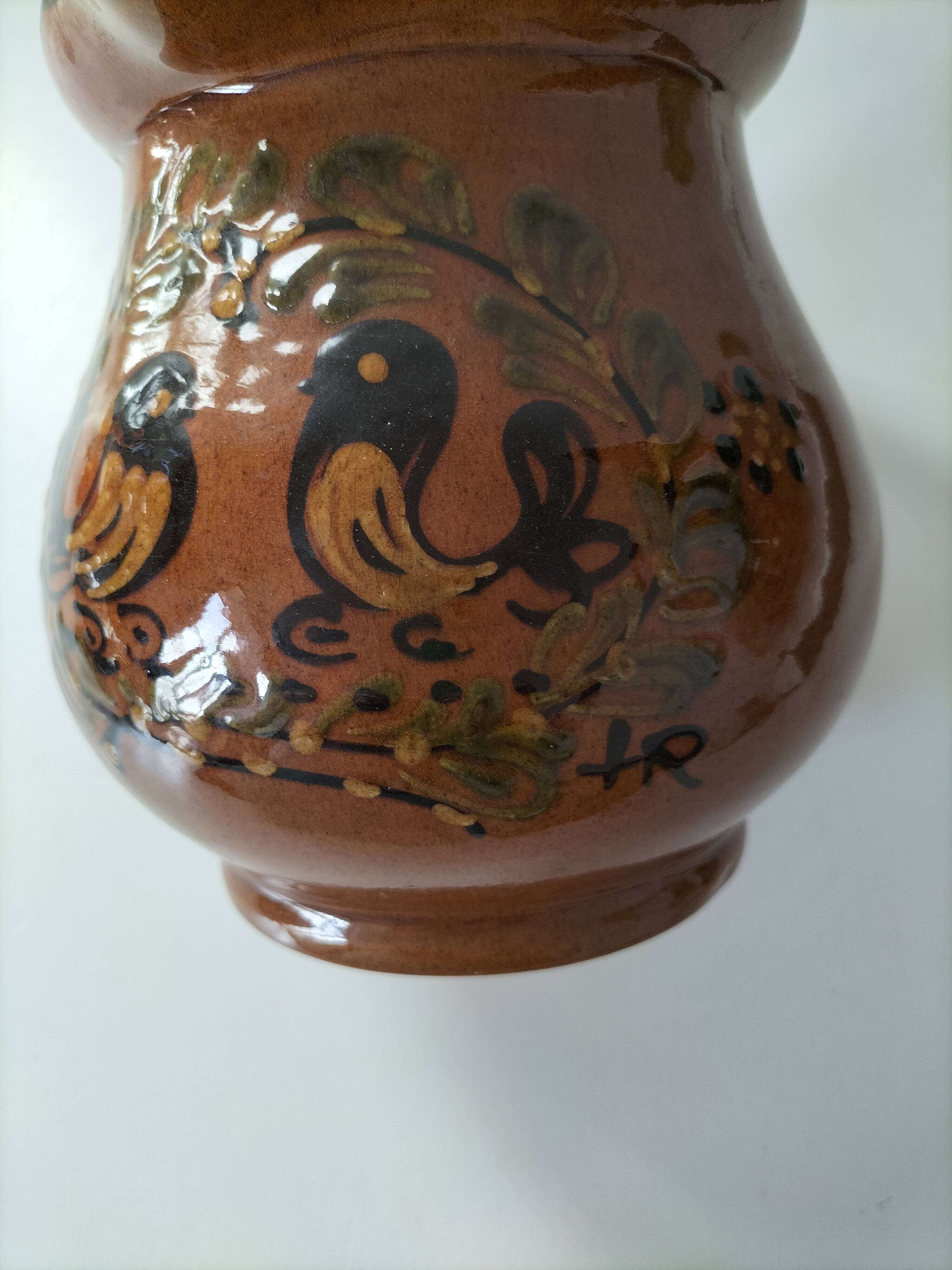 Glazed earthenware pitcher signed HR with a design of stylised birds.