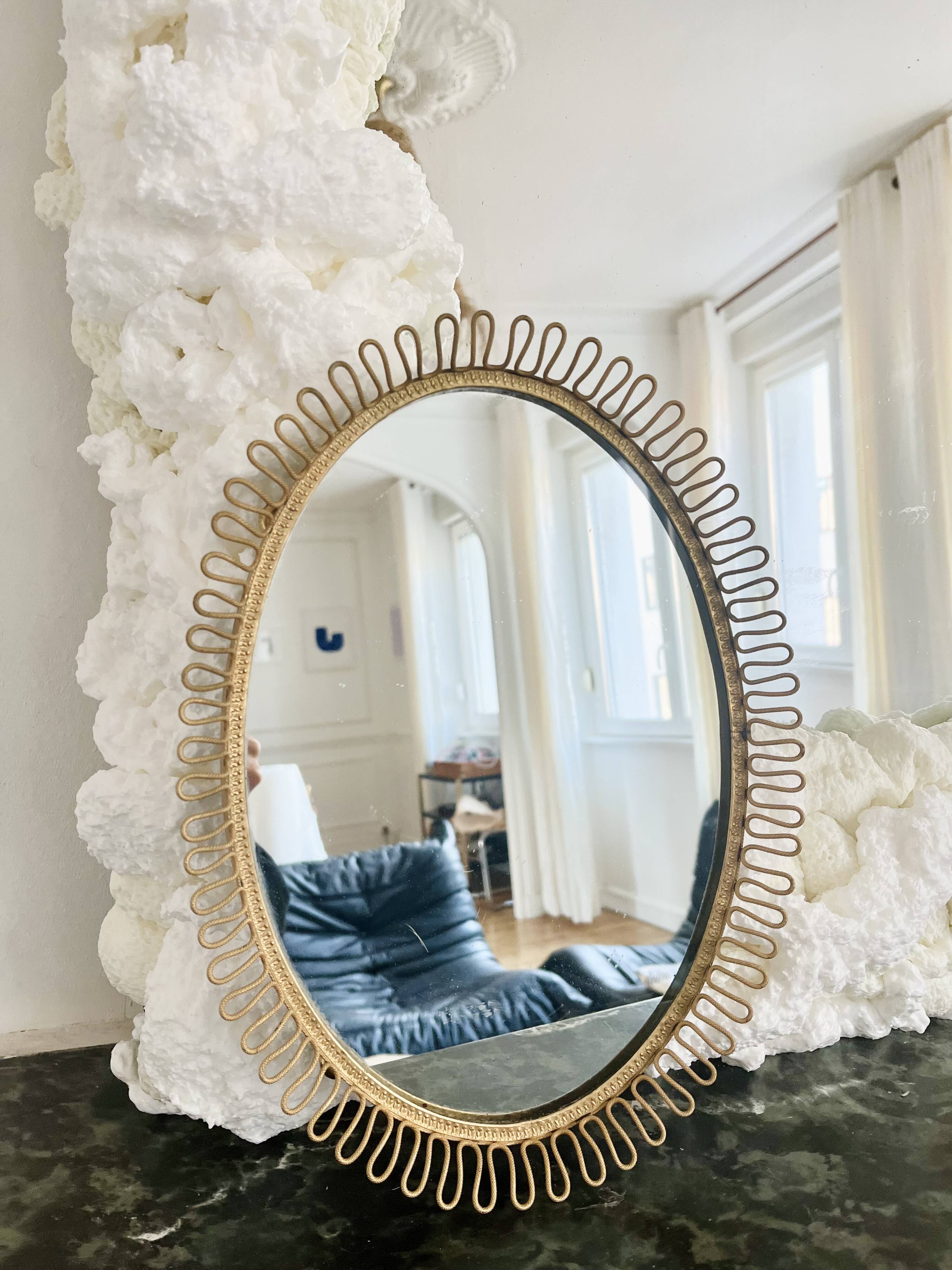 Oval mirror in gold metal