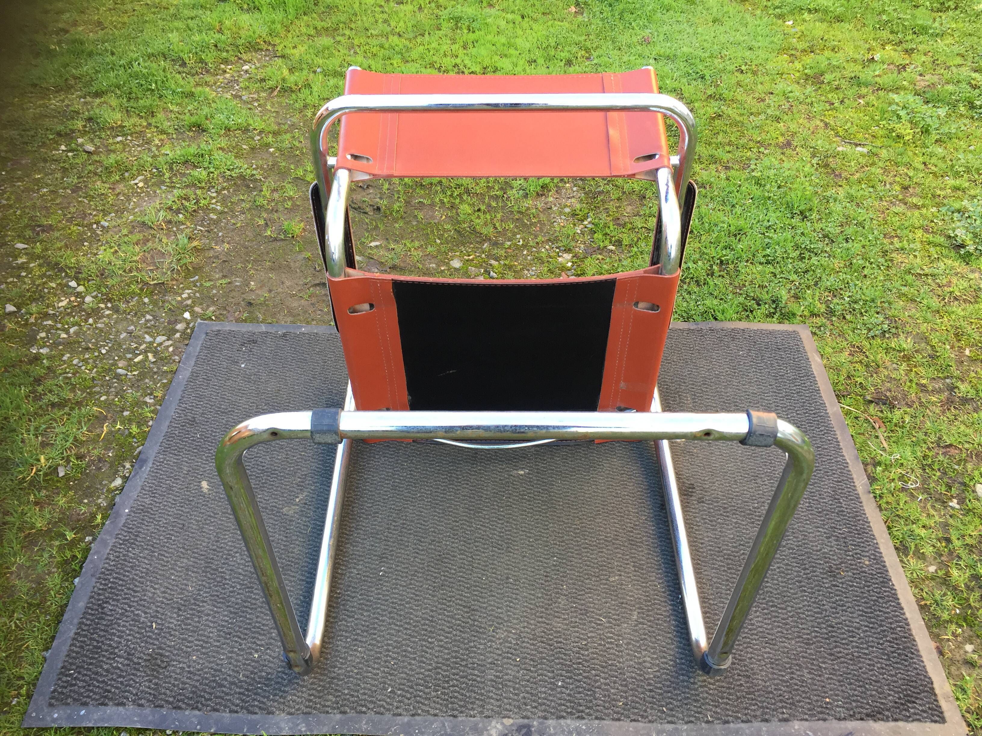 Design armchair with base in chrome tubular steel and seat in brown leather