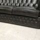 Three-seater black leather chesterfield sofa