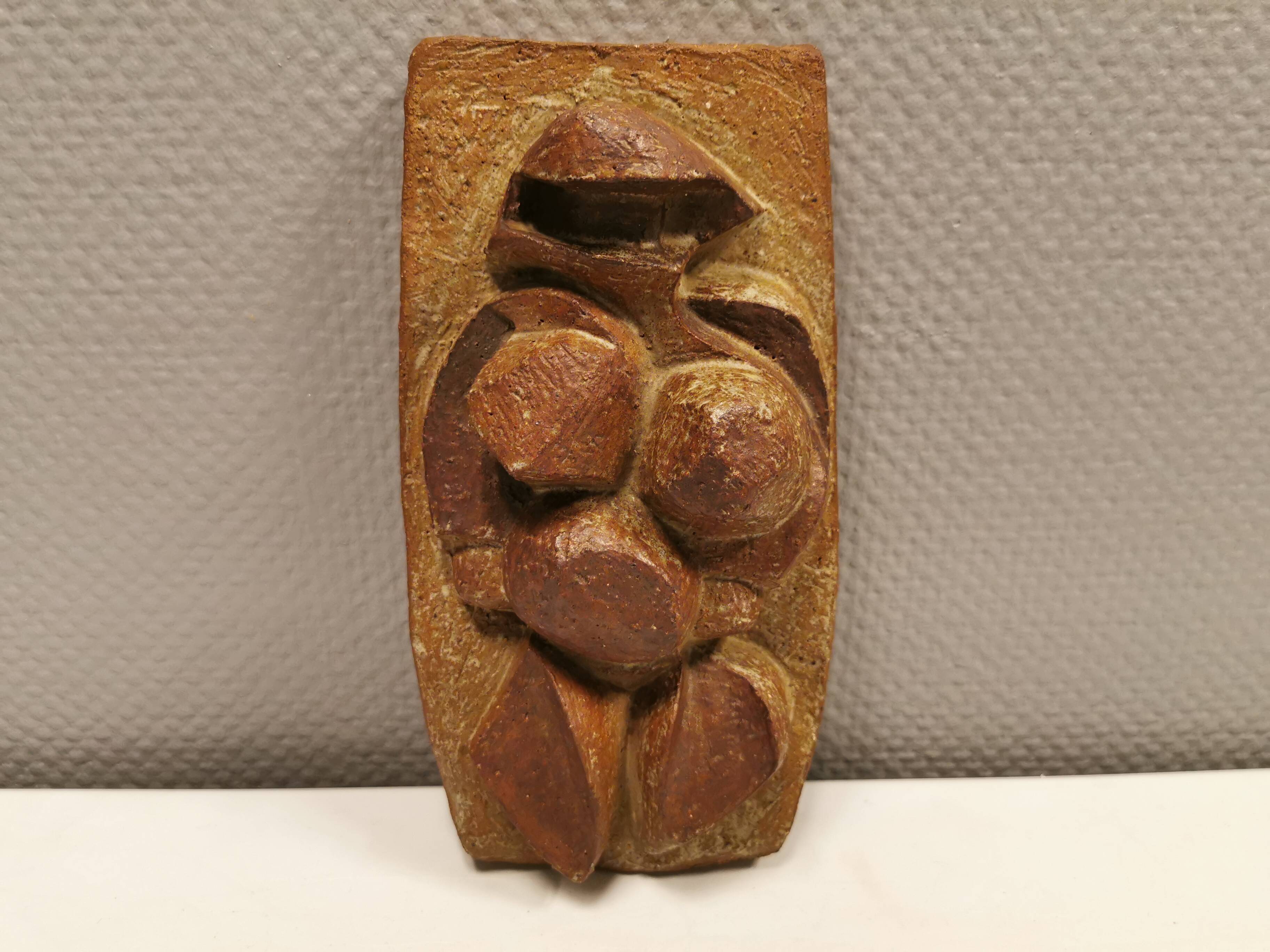 Ceramic relief portraying a lady. Emerging out of the background.