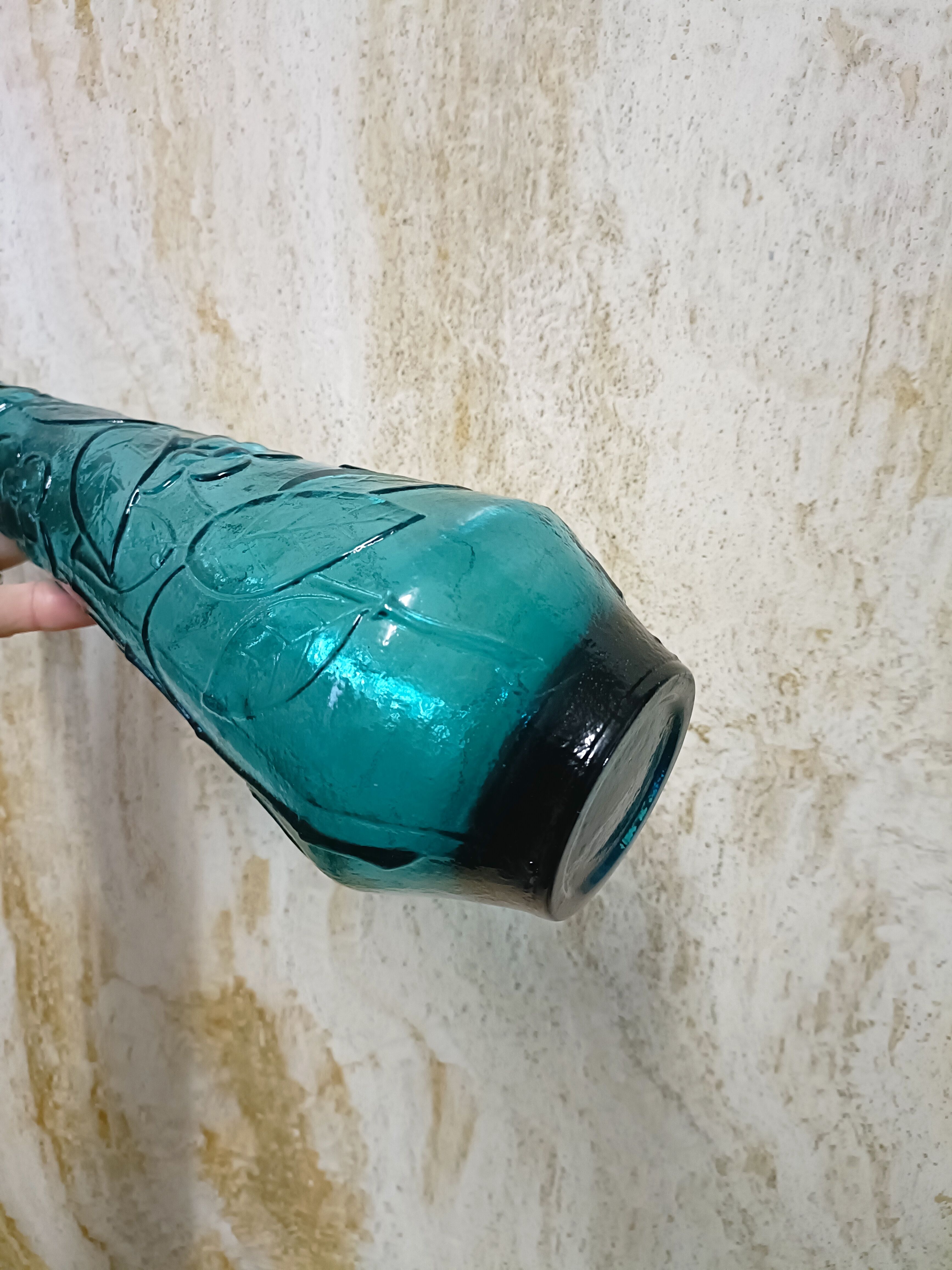 Blue pressed glass bottle decorated with flowers