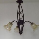 French Art Nouveau leaf detail iron three-light chandelier with amber glass shades.