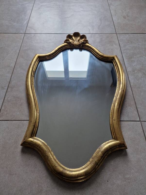 Carved and gilded wooden mirror, the pediment decorated with a shell.