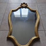Carved and gilded wooden mirror, the pediment decorated with a shell.