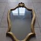 Carved and gilded wooden mirror, the pediment decorated with a shell.
