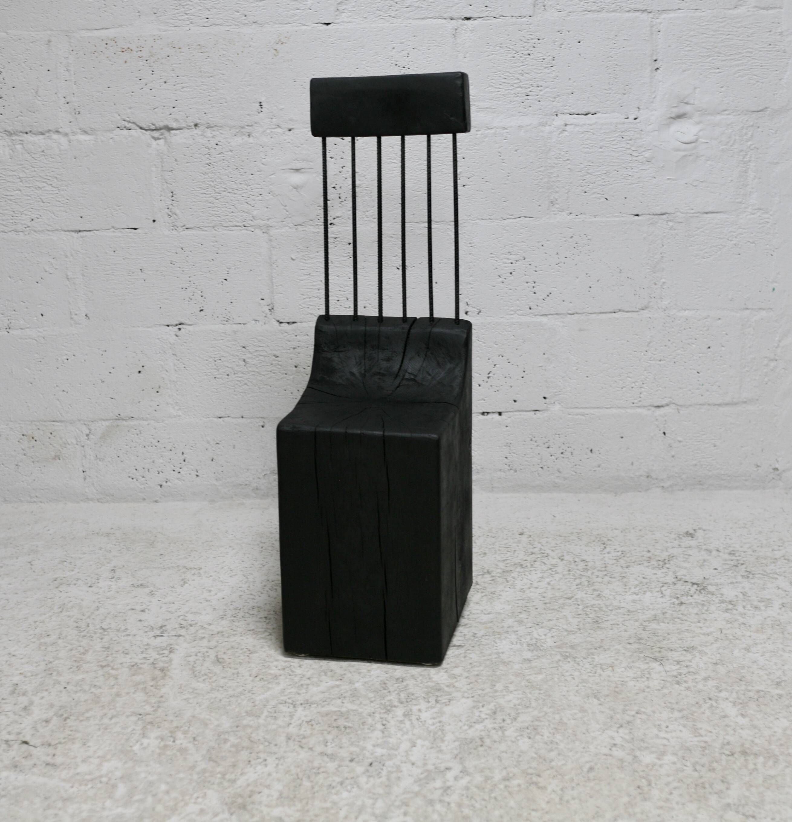Brutalist chair, black-stained raw wood, steel. Work from the 1970s