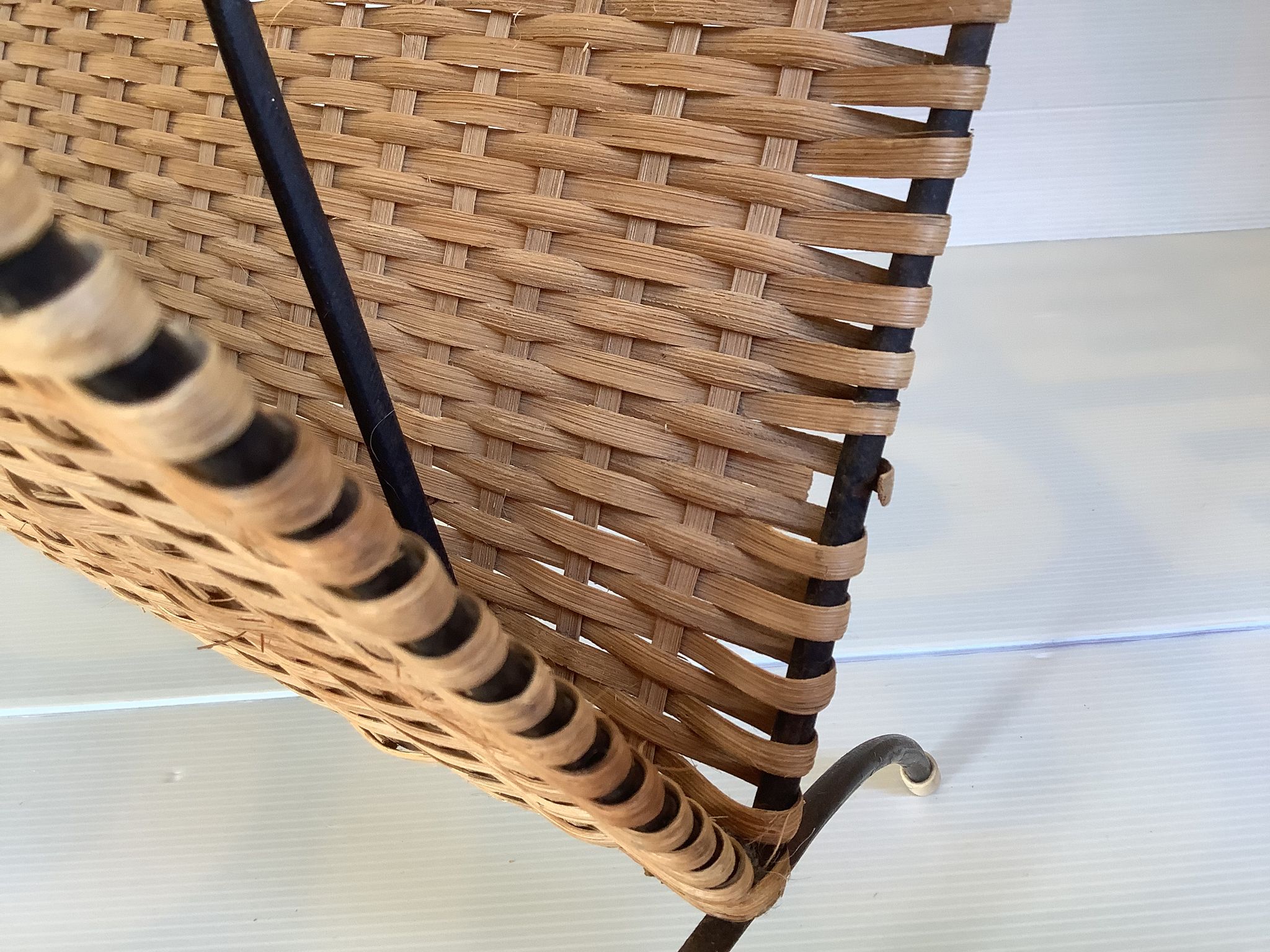 Old magazine rack in straw and black metal