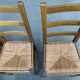 6 light solid wood chairs with high straw backs, farmhouse style.