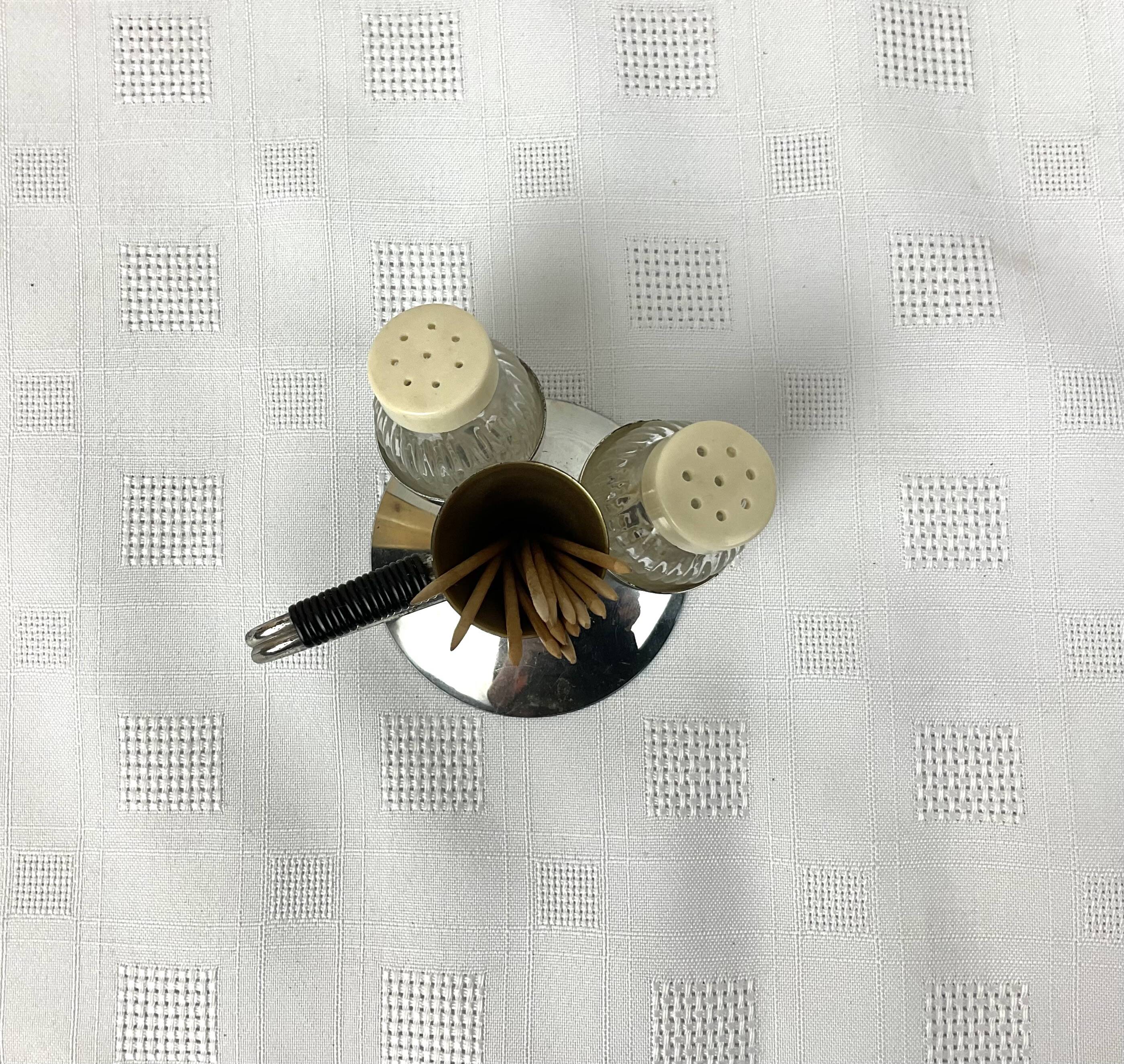 Vintage salt and pepper shakers and their chrome metal support