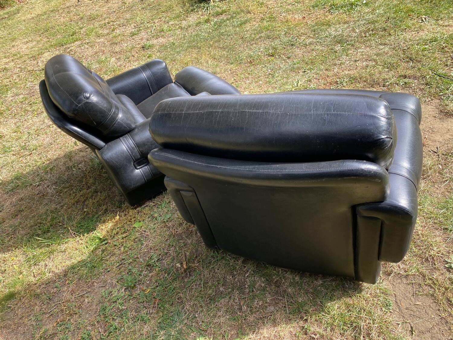 Pair of black imitation leather armchairs