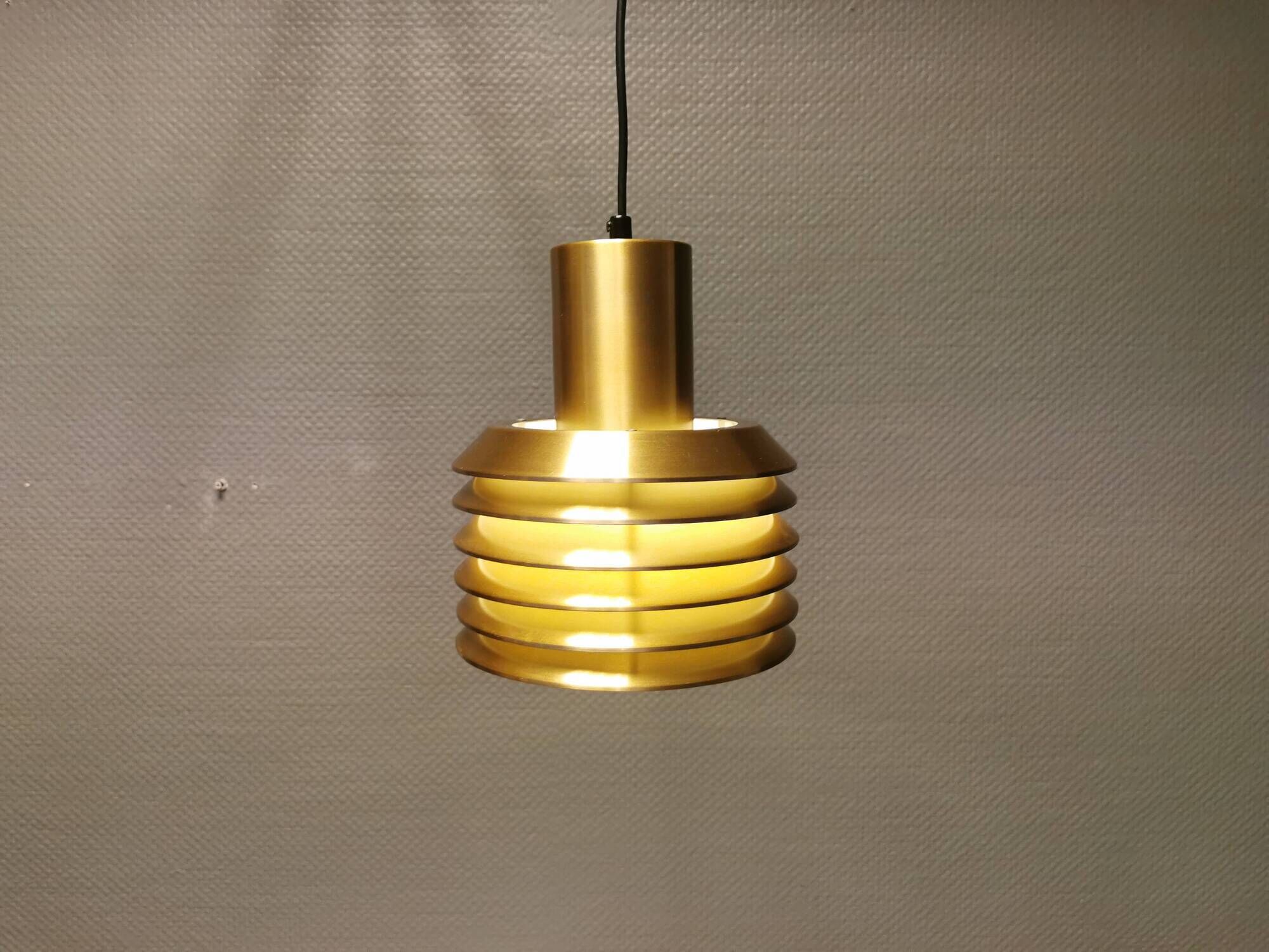 Hanging lamp in gold-colored aluminum with many layers of shades.