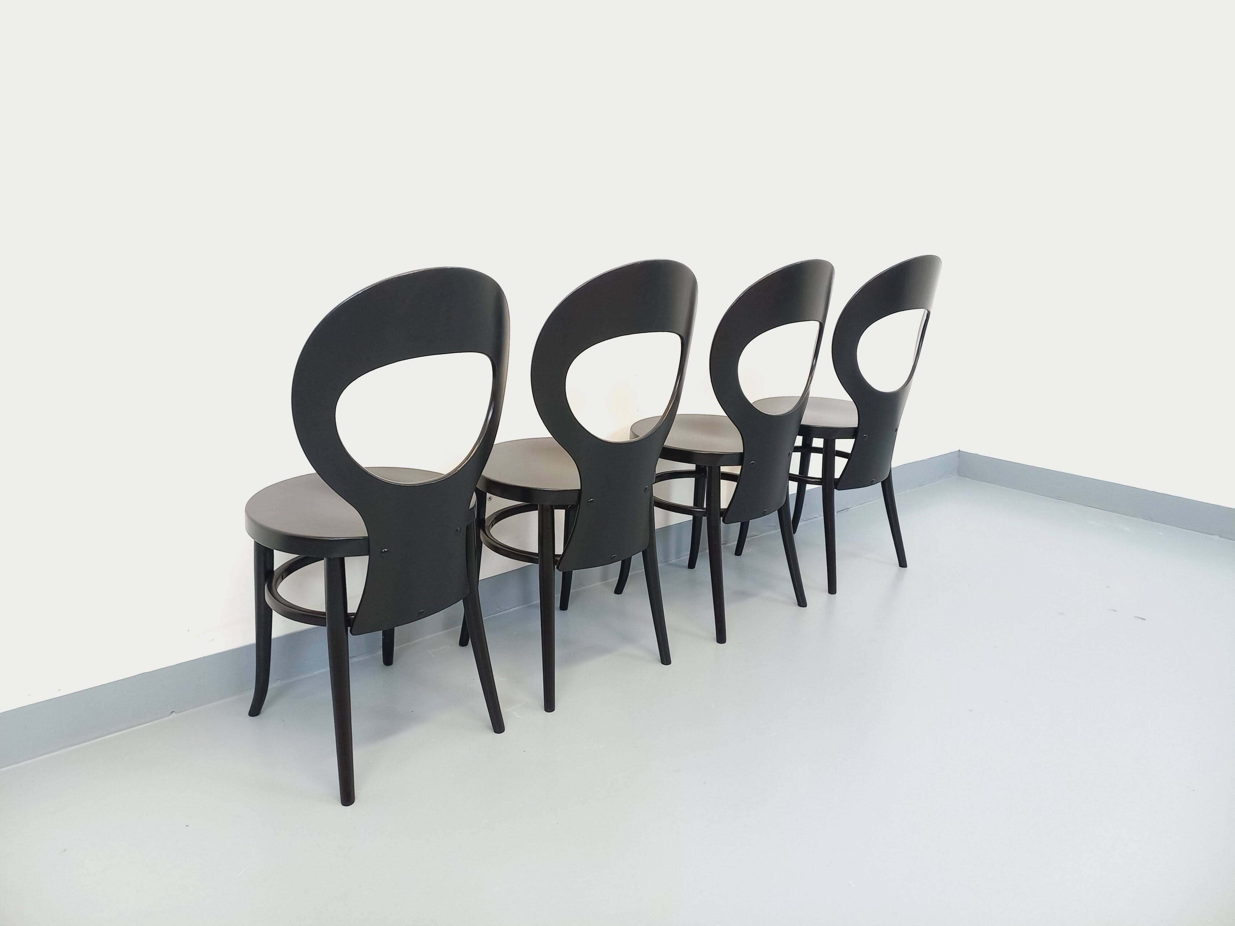 Set of 4 vintage Mouette chairs by Baumann in black wood from the 1960s.