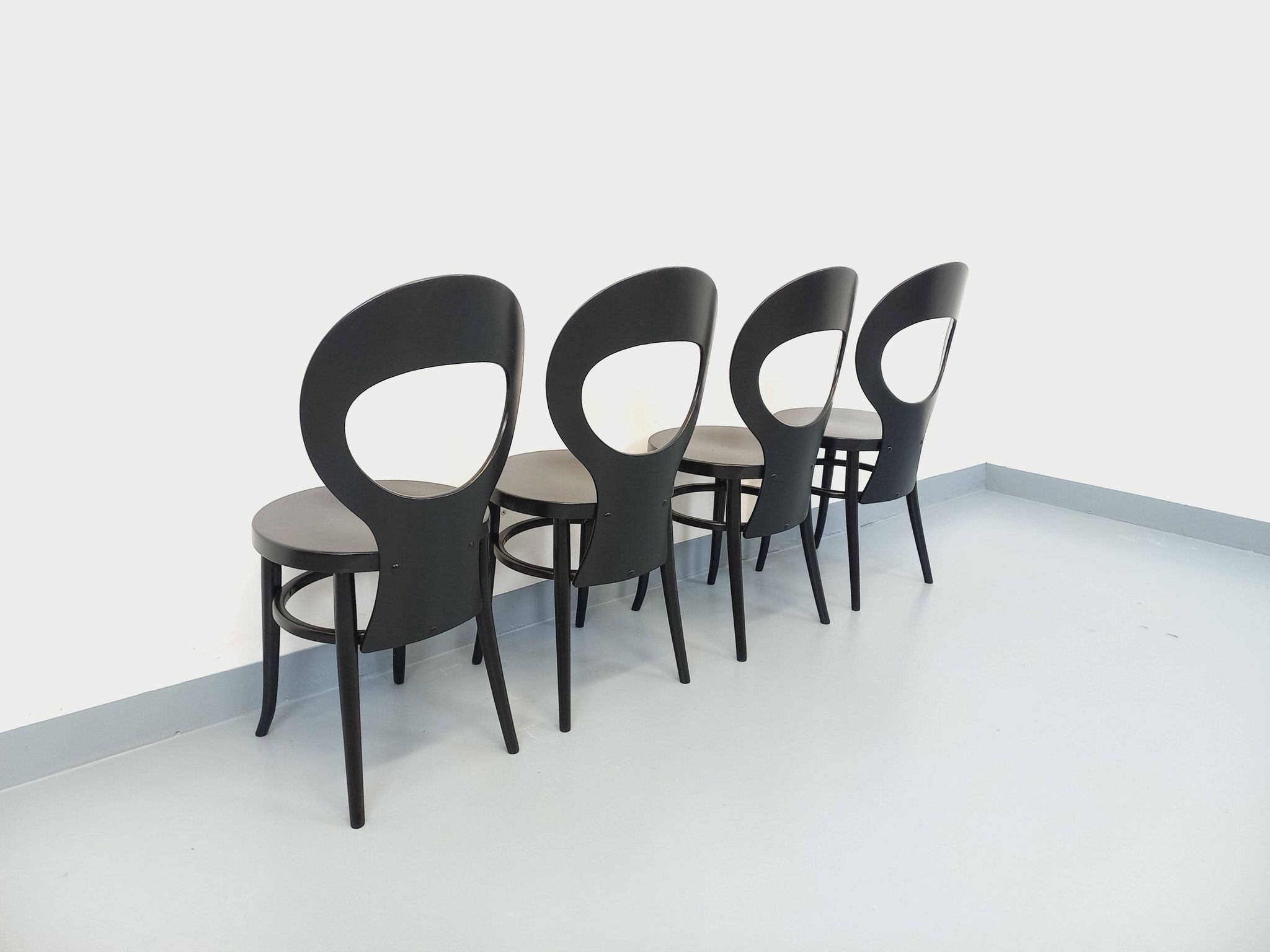 Set of 4 vintage Mouette chairs by Baumann in black wood from the 1960s.