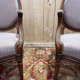 Pair of Louis XVI cabriolet armchairs with medallion backrest.