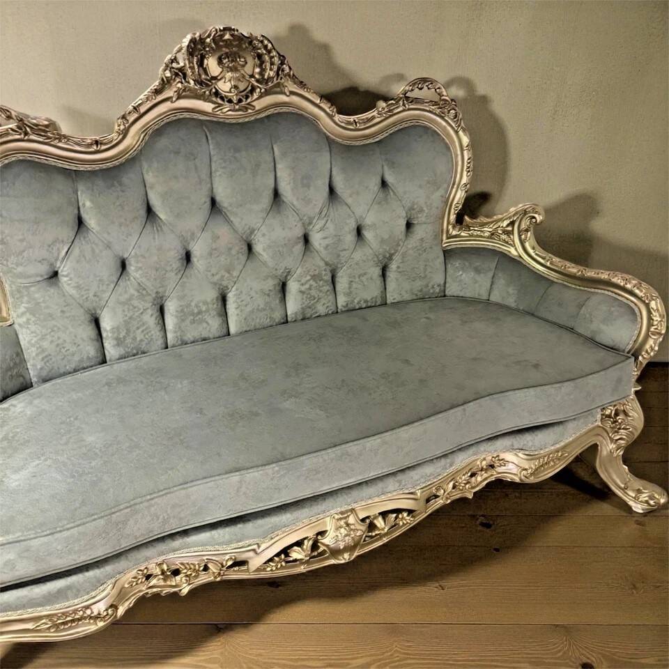 A soft light blue and silver tufted beech wood sofa in Louis style.