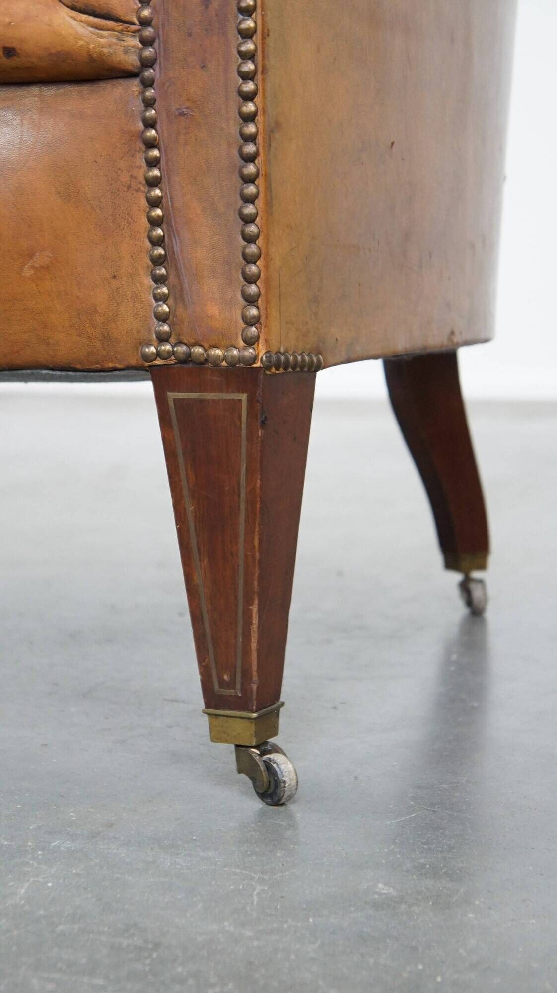 Antique, characteristic sheepskin chesterfield club chair on wheels