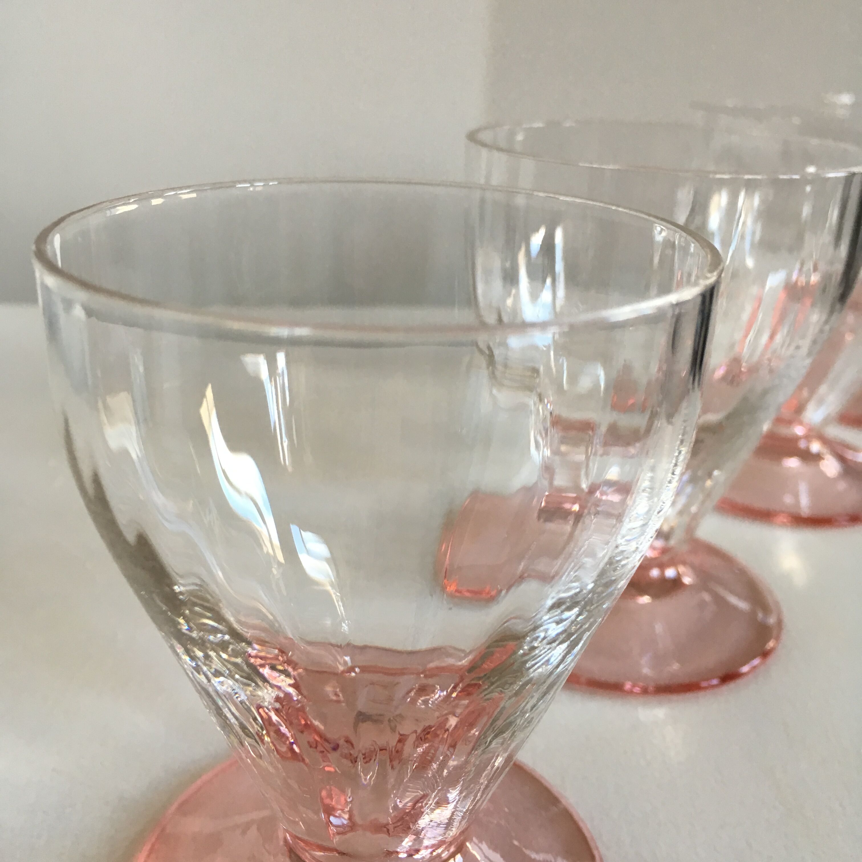 Lot of water in white and pink glass glasses