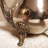 Silver-plated coffee and tea service including a coffee pot, a teapot, and a sugar bowl.