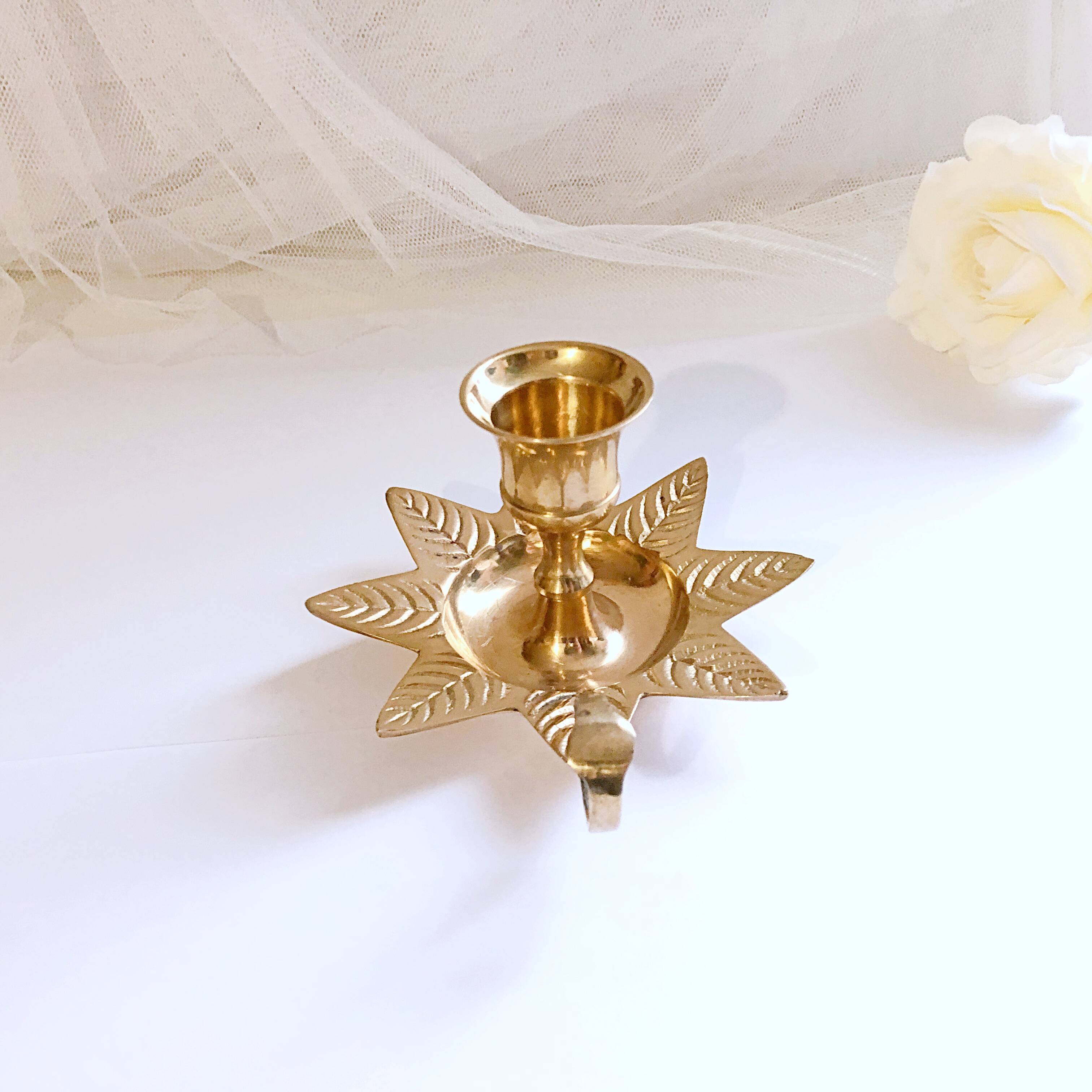 Golden brass hand candle holder decorated with leaves