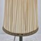 Brass table lamp with green patina and empire-style fabric shade.