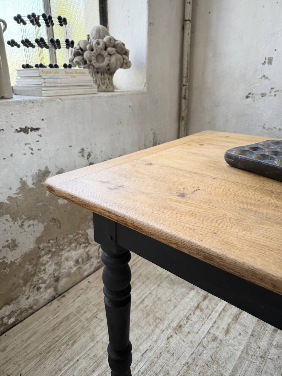 Oak farmhouse table with turned black legs.