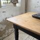 Oak farmhouse table with turned black legs.