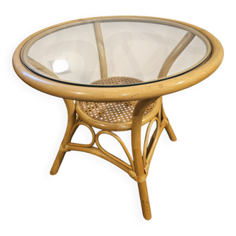 Vintage side table in rattan, caning, and glass top.