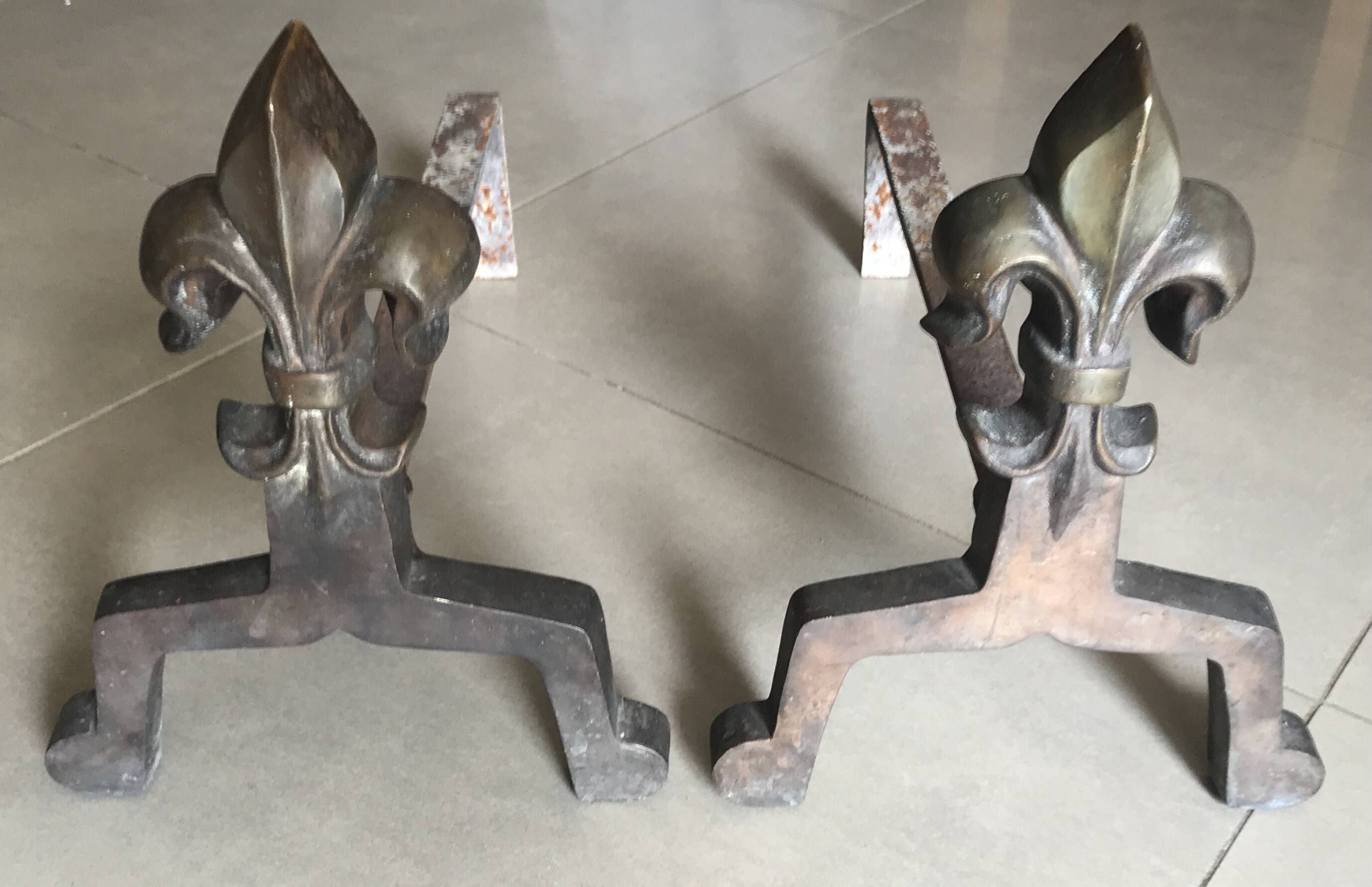 Pair of bronze fireplace firedogs with fleur-de-lys decor, art deco