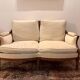 Two-seater canapé by Roche Bobois in Louis XVI style — carved wood, caned sides.
