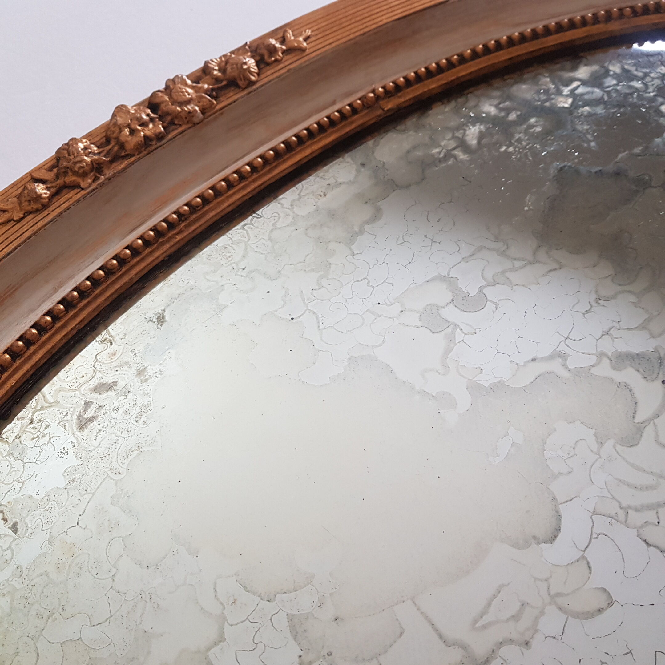 Large oval mirror with bevelled ice in stucque and wood decorated with flowers