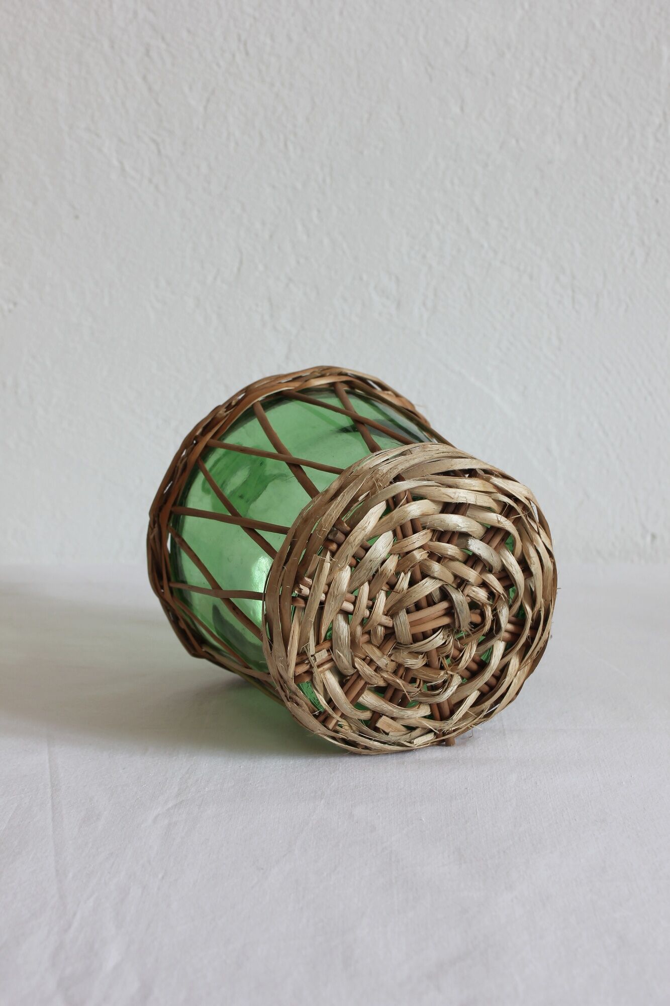 Dame jeanne verte vintage entourée de rotin / osier