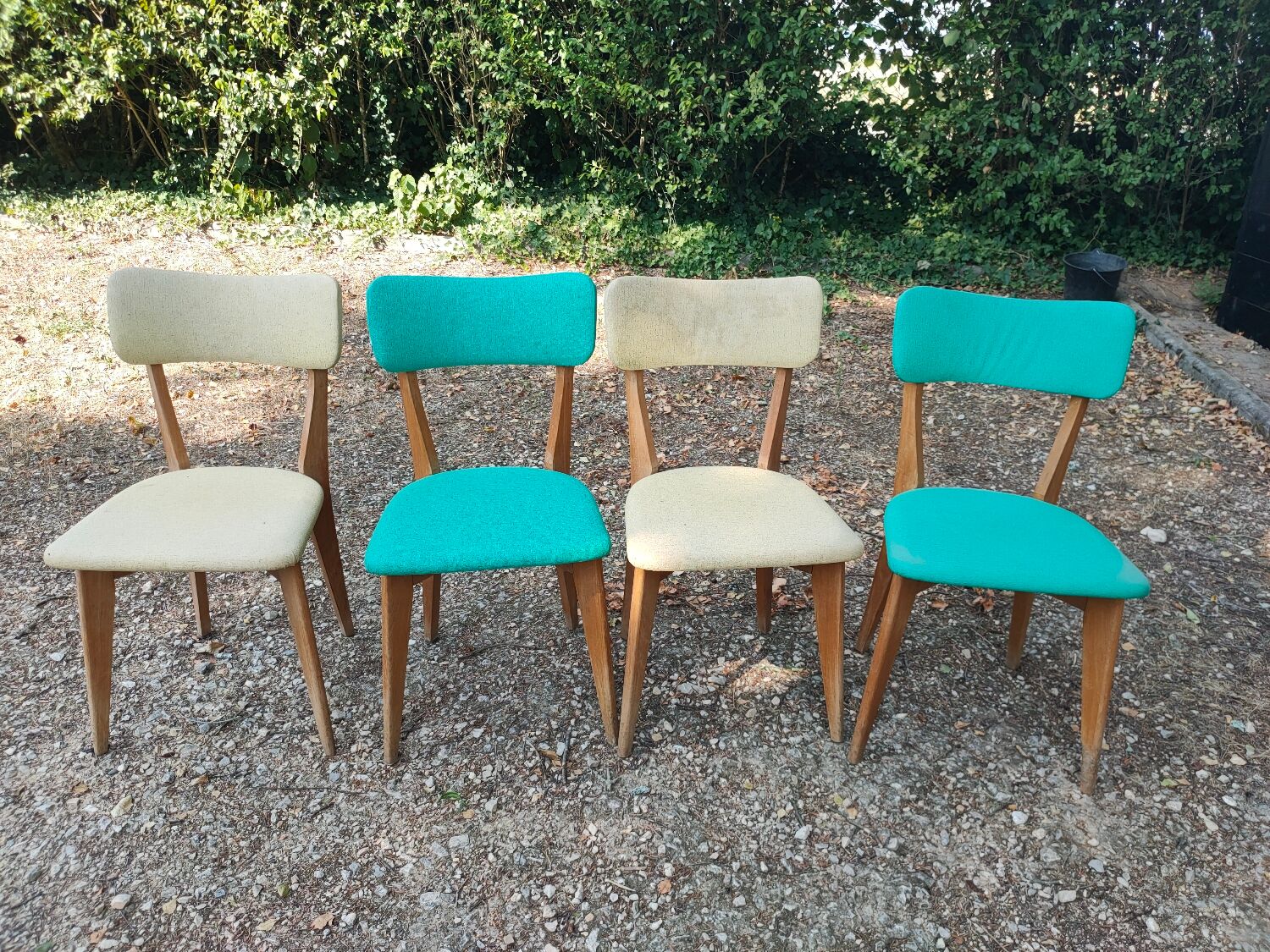 Set of 4 vintage chairs in wood and imitation blue leather dating from the 50s. Wooden structure. Seat and backrest in imitation leather 2 mint green and 2 yellow. Seating dimension: 46 cm. Good state of conservation, some traces of wear.