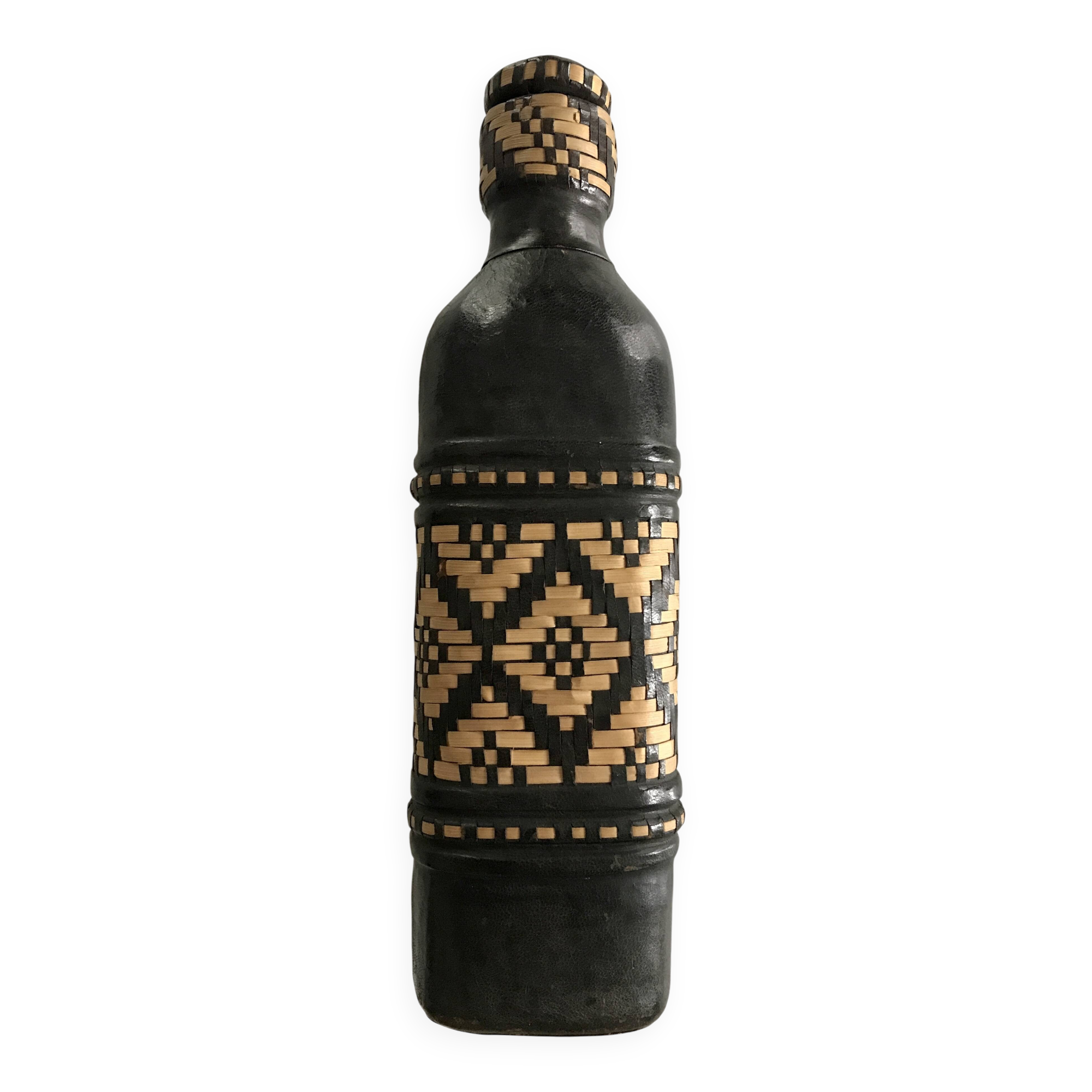 Ethnic decorative bottle in leather and raffia braiding