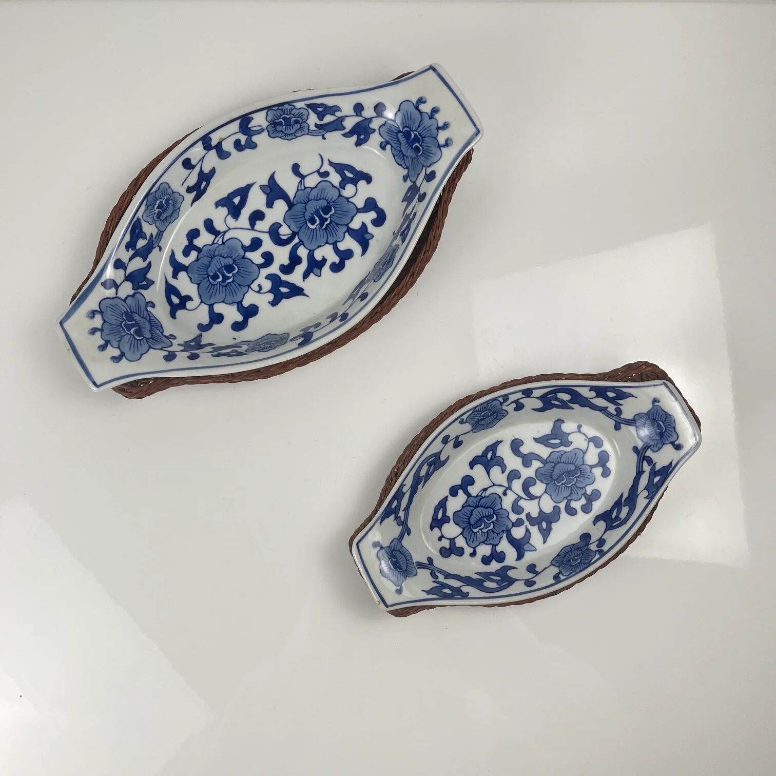 Set of 6 ceramic presentation plates in white and blue, floral pattern with woven wicker frame, 1970s/80s.